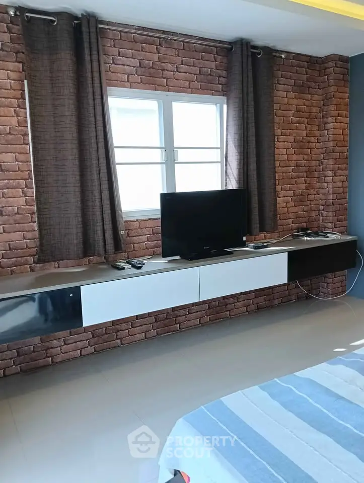 Modern living room with exposed brick wall and sleek TV setup