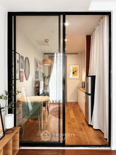 Modern apartment with open kitchen and dining area featuring sleek design and natural light.