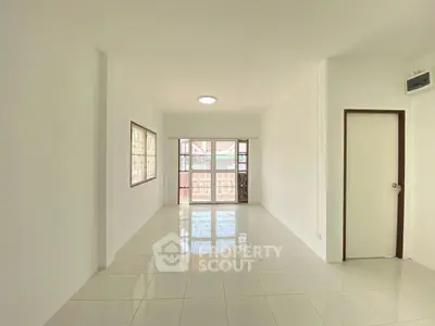 Spacious and bright living room with large windows and tiled flooring