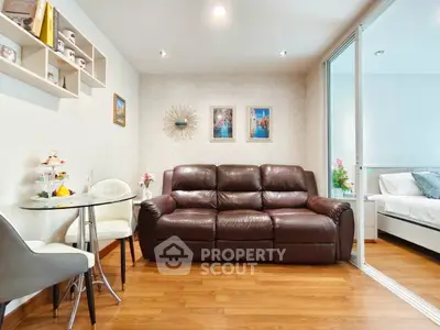 Charming living room with cozy leather sofa and elegant decor, adjacent to a stylish bedroom.