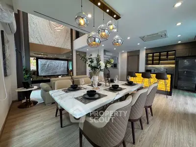 Luxurious open-plan living and dining area with modern decor and elegant lighting.