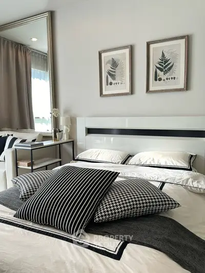 Stylish bedroom with modern decor and elegant framed artwork, featuring a cozy bed and chic pillows.