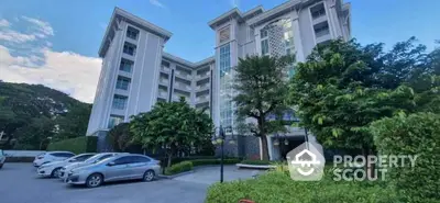 Elegant residential building with lush greenery and ample parking space