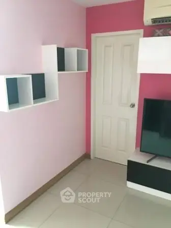 Modern living room with pink accent wall and sleek shelving unit.