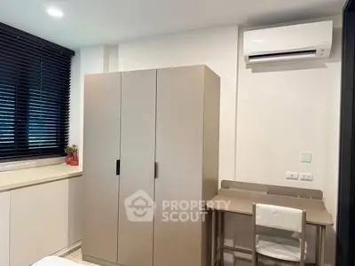 Modern bedroom with sleek wardrobe and air conditioning unit, perfect for comfortable living.