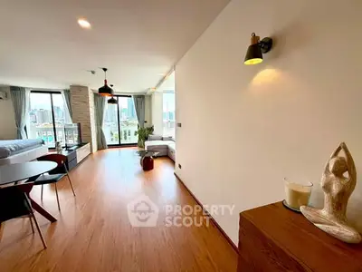 Spacious modern living room with wooden flooring and city view, perfect for urban living.