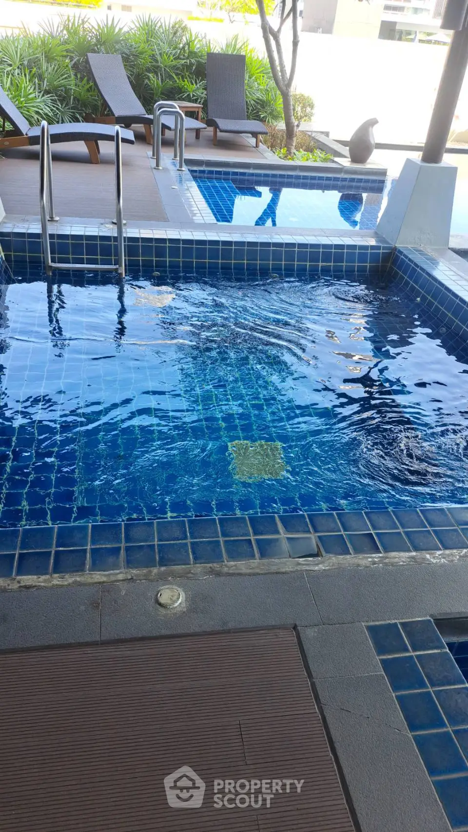 Luxurious poolside area with modern design and lush greenery, perfect for relaxation and leisure.