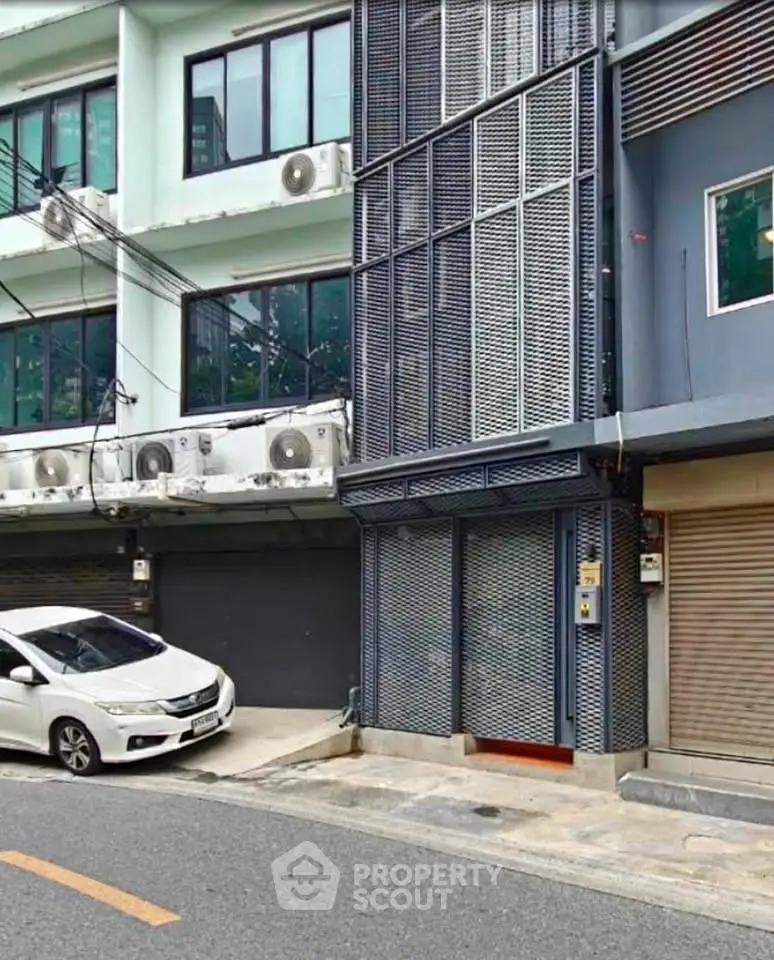 Modern urban building exterior with sleek design and street view, featuring large windows and secure entrance.