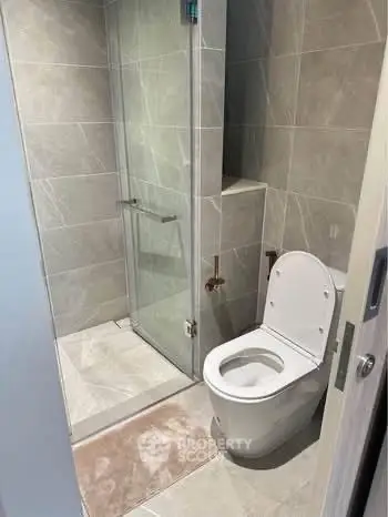 Modern bathroom with sleek shower and toilet in contemporary design.