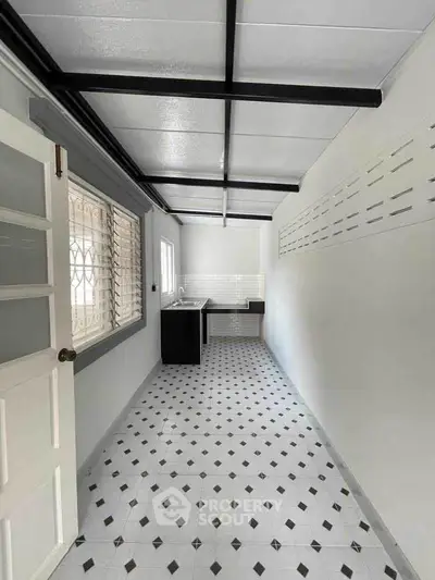 Spacious kitchen with modern tiled flooring and ample natural light.