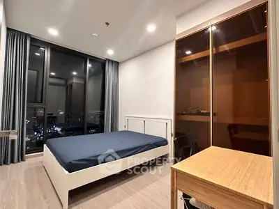 Modern bedroom with city view, featuring sleek furniture and floor-to-ceiling windows.