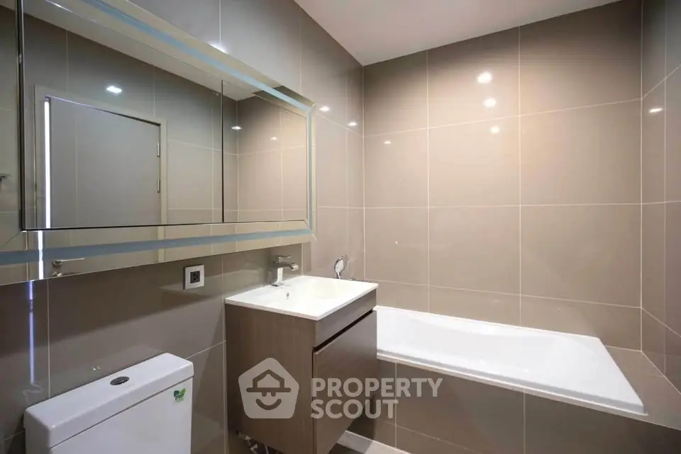 Modern bathroom with sleek design and bathtub in contemporary apartment.