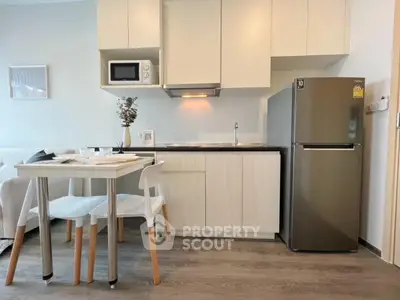 Modern compact kitchen with dining area and sleek appliances