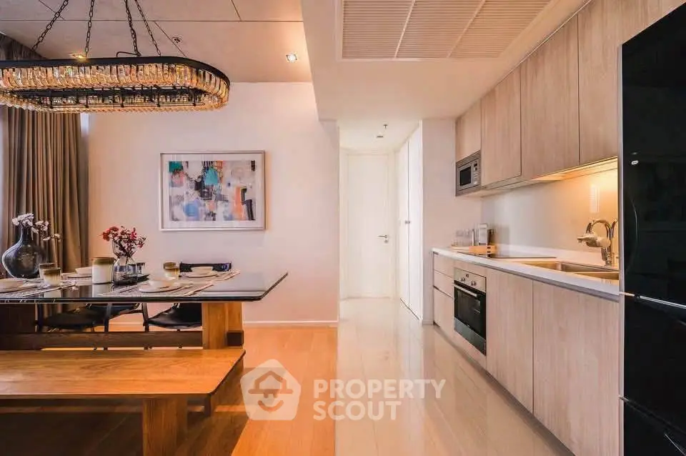 Modern kitchen with open layout and elegant dining area featuring a chic chandelier.