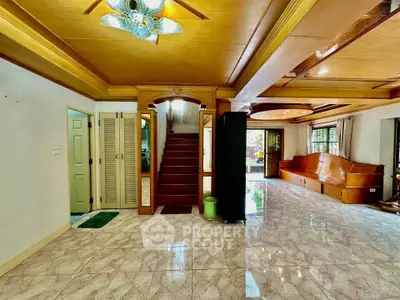Spacious living room with elegant wooden ceiling and marble flooring