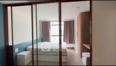 Modern bedroom with large window and stylish furnishings in a contemporary apartment.