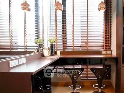 Modern kitchen with sleek design and stylish bar stools, featuring large windows with blinds.