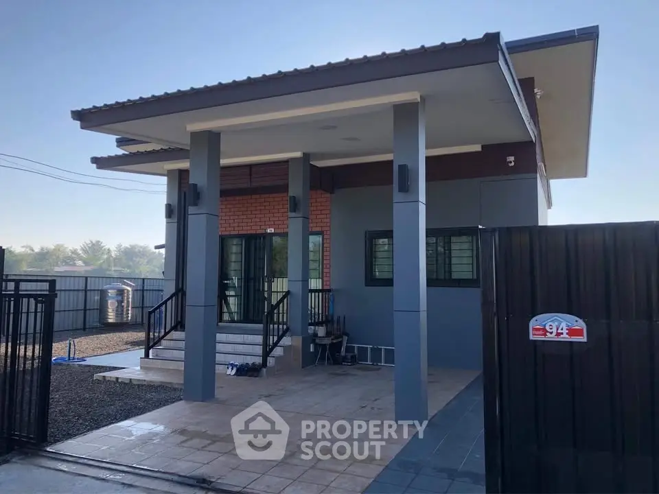 Modern single-story house with sleek design and spacious front porch, perfect for contemporary living.