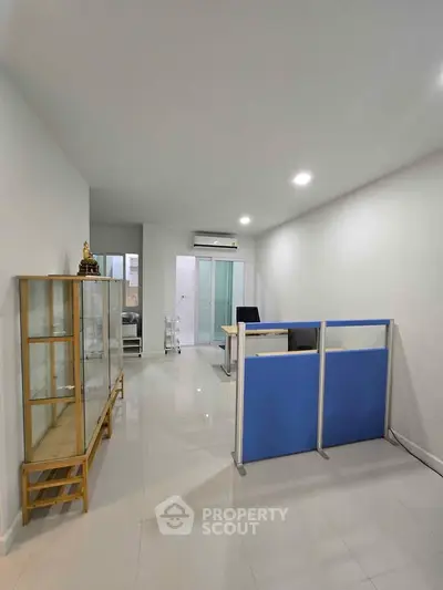 Modern office space with sleek design and glass cabinet for display.