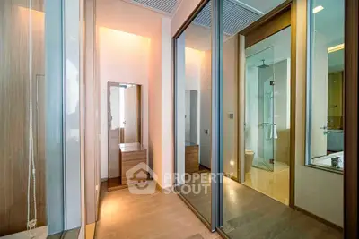 Modern bathroom with sleek design and mirrored closet doors in a luxury apartment.