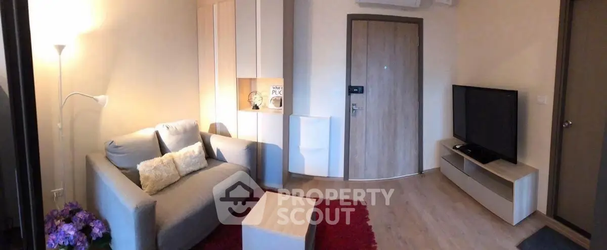 Cozy living room with modern decor and flat-screen TV, perfect for relaxation.