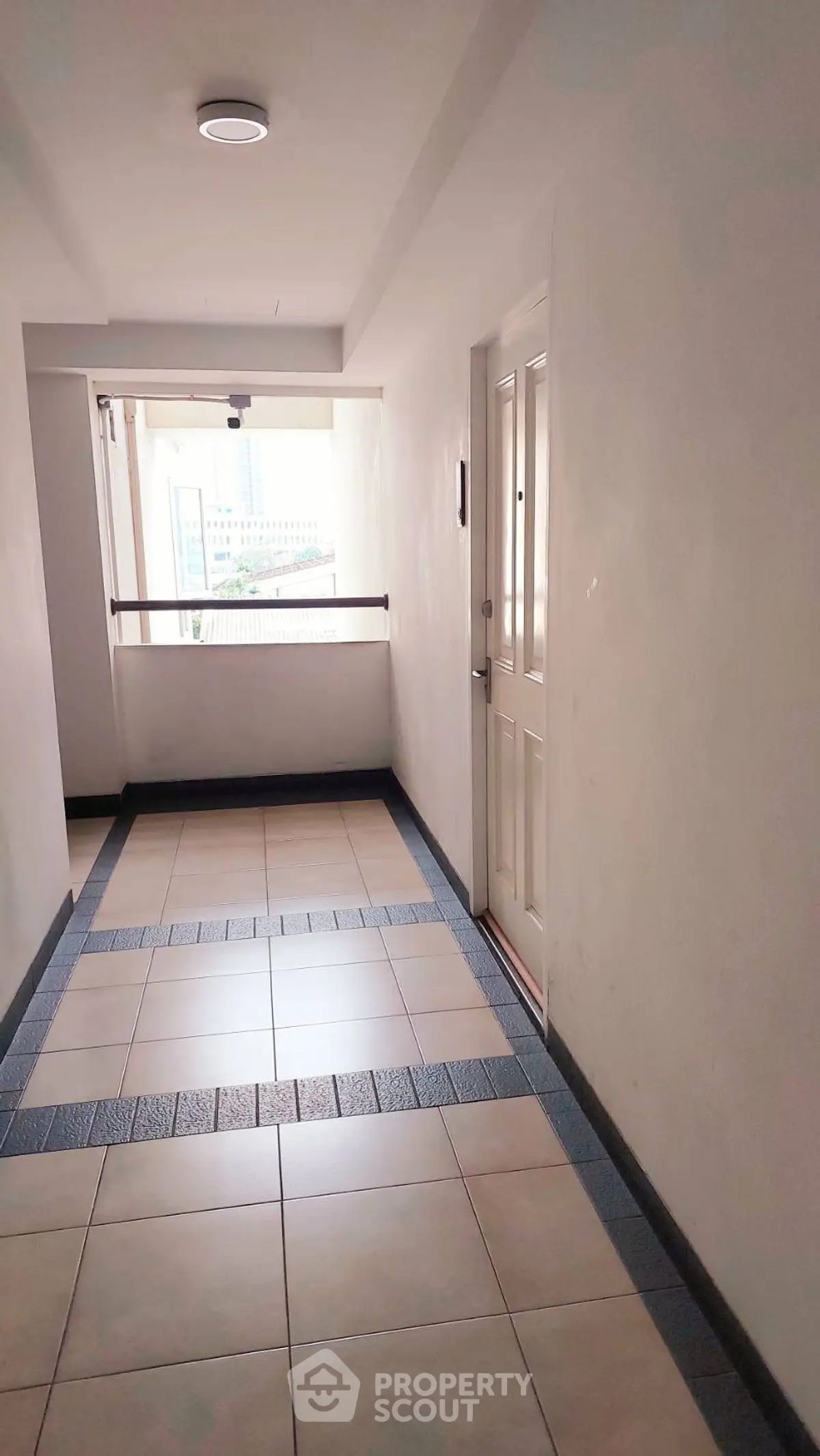 Bright apartment corridor with tiled flooring and natural light