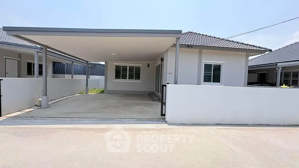 Modern single-story house with carport and minimalist design.