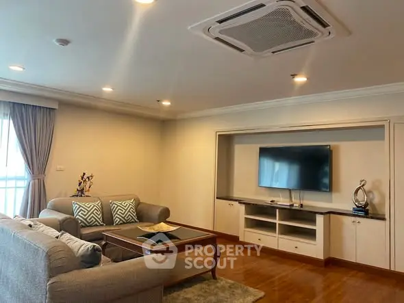 Spacious living room with modern decor and built-in entertainment center.