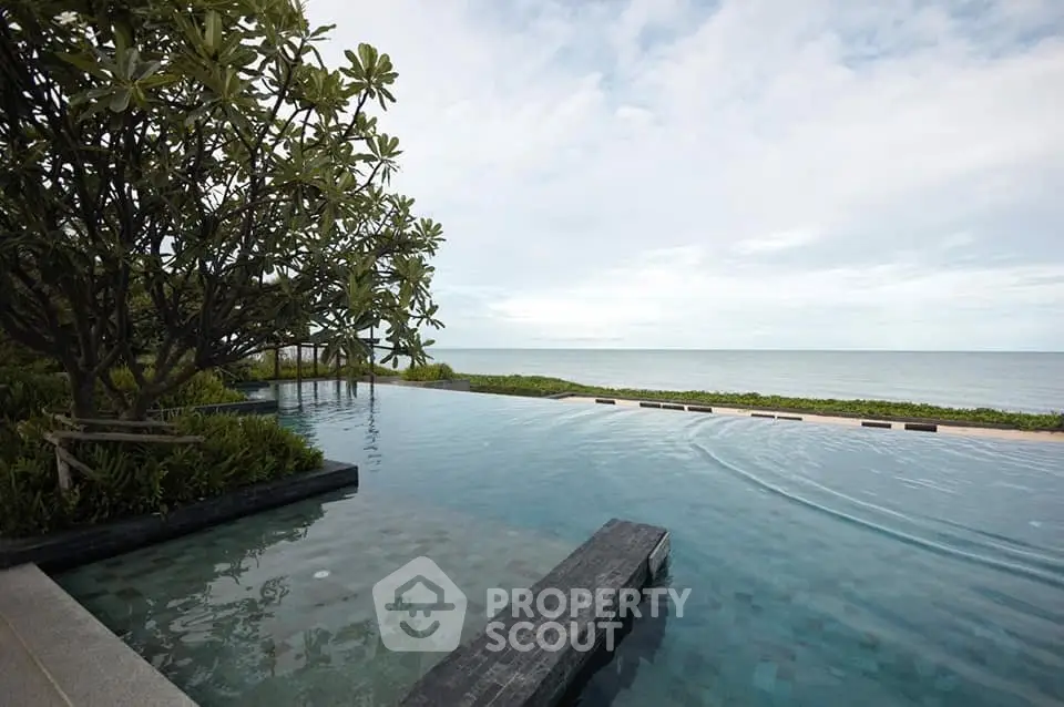 Luxurious infinity pool with stunning ocean view and lush greenery, perfect for relaxation and leisure.