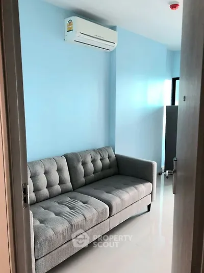 Cozy small living room with modern gray sofa and blue walls
