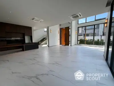 Expansive modern living space with gleaming marble floors, floor-to-ceiling windows, and a sleek kitchen, perfect for entertaining.