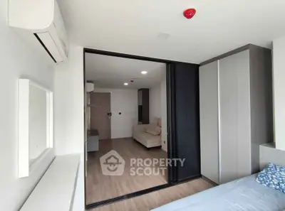 Modern apartment interior with sliding doors and air conditioning, featuring a cozy living area and bedroom.