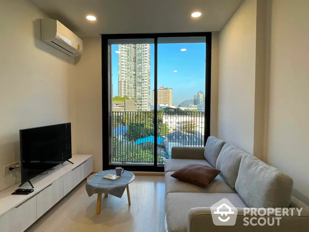 Modern living room with city view, sleek furniture, and large window for natural light.