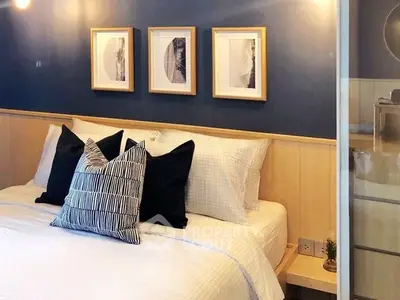 Cozy bedroom with stylish decor and framed art on blue accent wall.