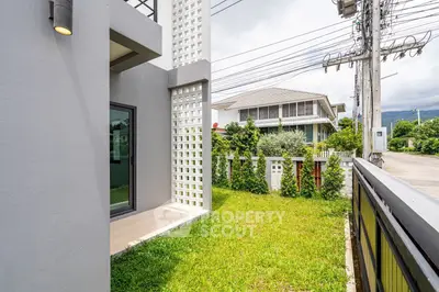 Modern house exterior with lush green lawn and contemporary design elements.
