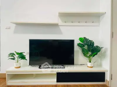 Modern living room with sleek TV stand and lush green plants enhancing the decor.