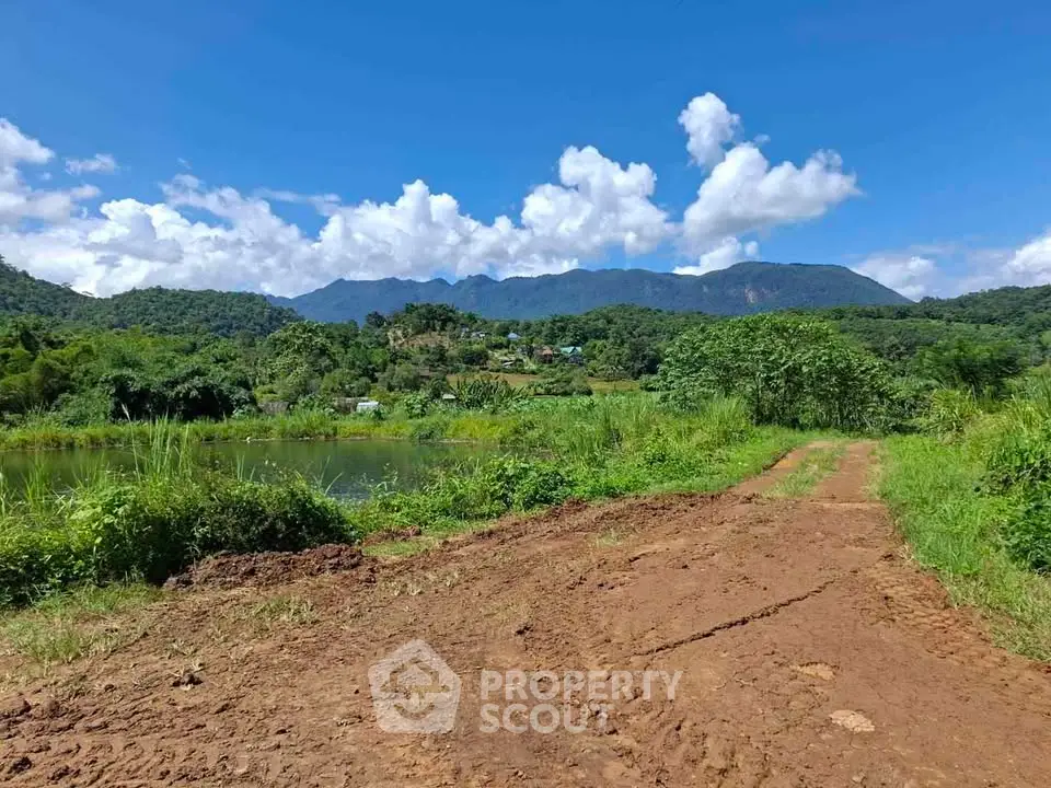 Scenic rural land with lush greenery and mountain views, perfect for development or agriculture.