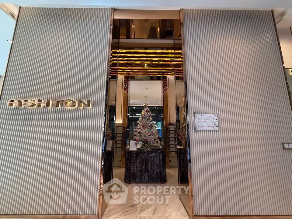 Luxurious building entrance with elegant decor and festive Christmas tree display.