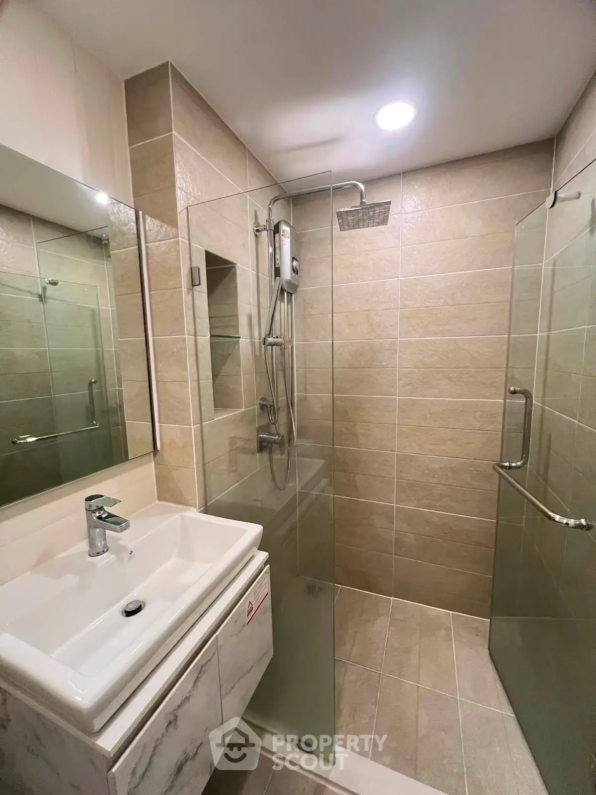 Modern bathroom with glass shower enclosure and sleek vanity in a contemporary home.