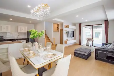 Spacious open-plan living and dining area with modern kitchen and elegant decor.