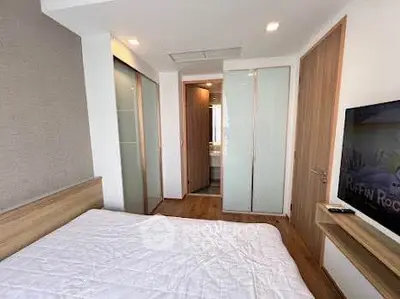 Modern bedroom with wooden accents and sliding closet doors in a stylish apartment.