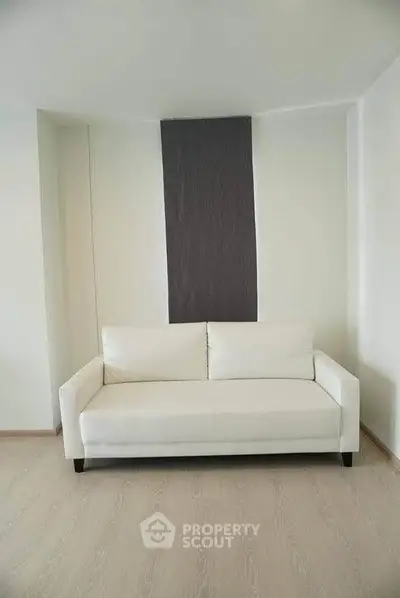 Modern minimalist living room with sleek white sofa and stylish decor.