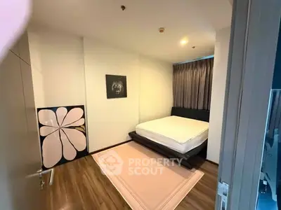 Modern bedroom with minimalist decor and wooden flooring in a stylish apartment.