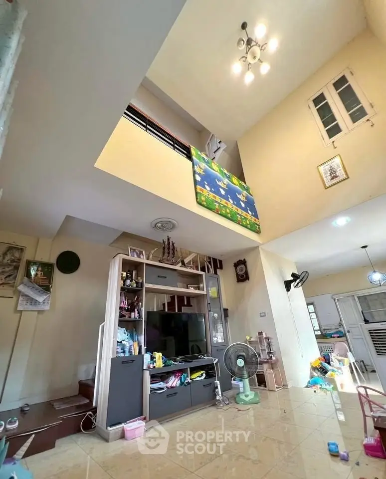 Spacious living room with high ceiling and modern decor in a family-friendly home.