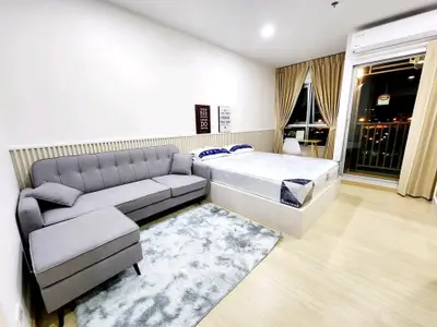Modern studio apartment with cozy living area and balcony view