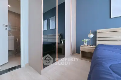 Modern bedroom with sleek mirrored wardrobe and cozy blue bedding