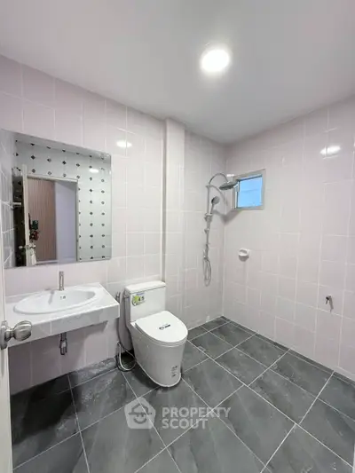 Modern bathroom with sleek tiles and contemporary fixtures in a stylish real estate property.