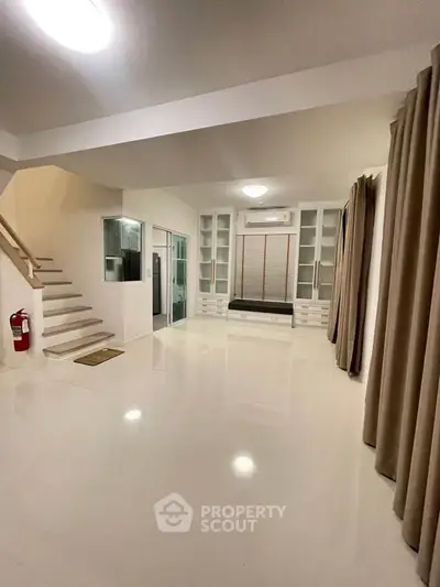 Spacious modern living room with sleek design and ample natural light, perfect for family gatherings.