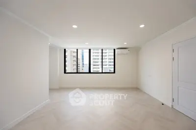 Spacious modern living room with large windows and elegant flooring