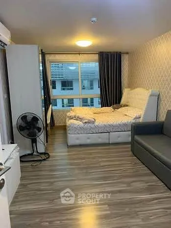 Cozy bedroom with modern decor and large window in a stylish apartment.